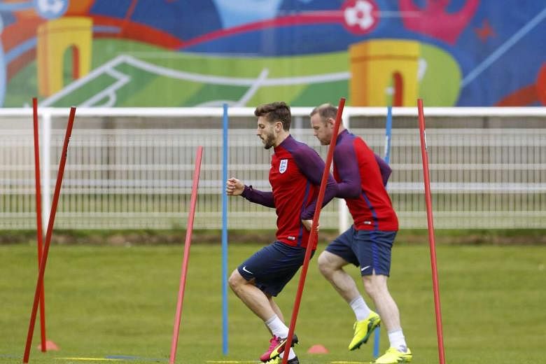 England's Adam Lallana (left) and Wayne Rooney during a training session at Stade des Bourgognes in Chantilly yesterday. Lallana has said that elimination due to fan violence would be "devastating", while captain Rooney and manager Roy Hodgson have appeal