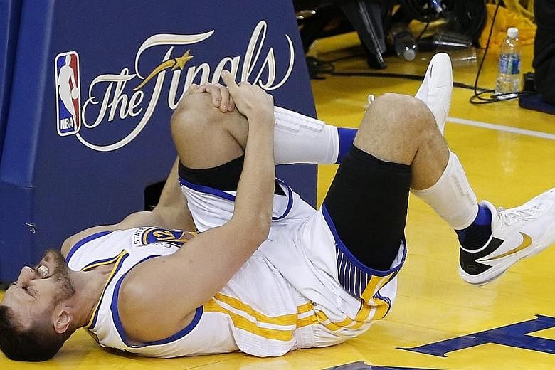 Warriors centre Andrew Bogut holding his knee in pain during Game 5 of the NBA Finals with the Cleveland Cavaliers. The Australian will miss the rest of the Finals.