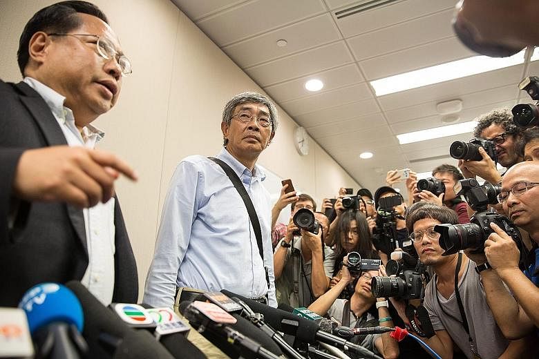 Mr Lam (centre), one of five people associated with Causeway Bay Bookstore who went missing last year, with Democratic Party lawmaker Albert Ho at a news conference held at the party's office in the Legislative Council complex in Hong Kong yesterday.