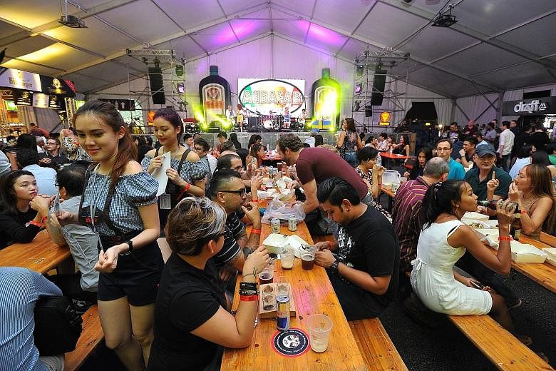 Above: RedDot BrewHouse's brewmaster Crystalla Huang Rui Qi, 25, holding up its signature craft beer infused with spirulina - the Monster Green Lager - at Beerfest Asia 2016 at the Marina Promenade yesterday. The brewery won the Best of Singapore awa