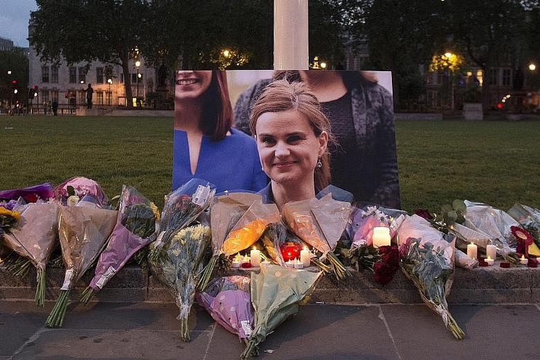 Floral tributes left in memory of Mrs Cox in Parliament Square, London, on Thursday. Mr Cameron has recalled Parliament on Monday to pay tribute to her.