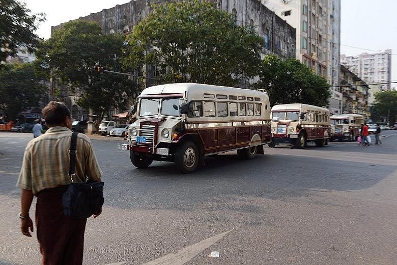 Period buses ferrying tourists around Yangon. By easing visa requirements for foreign travellers, Myanmar hopes to increase visitor arrivals and boost its tourism industry.
