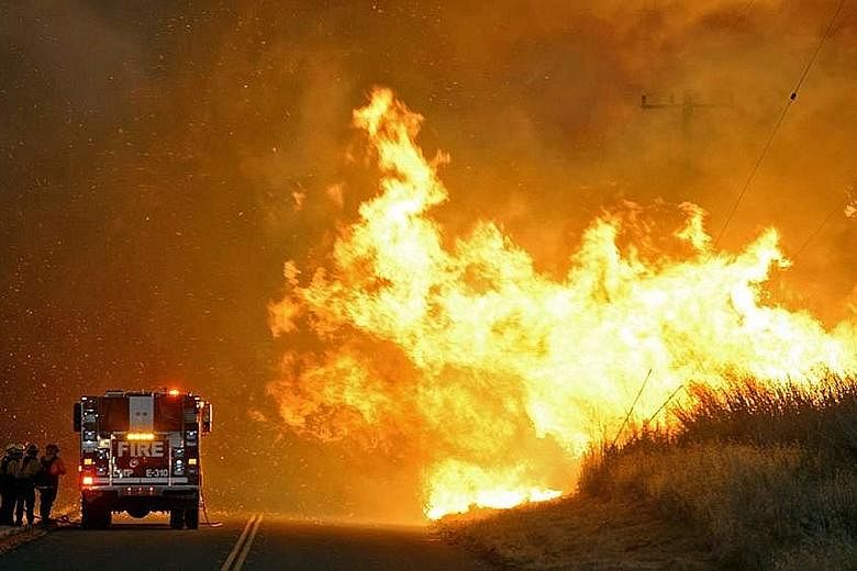 A fire crew sheltering behind an engine in the face of a blaze in Santa Barbara, California, in a photo released on Thursday. A combination of heat, drought and strong winds is threatening to make the wildfires unusually intense.