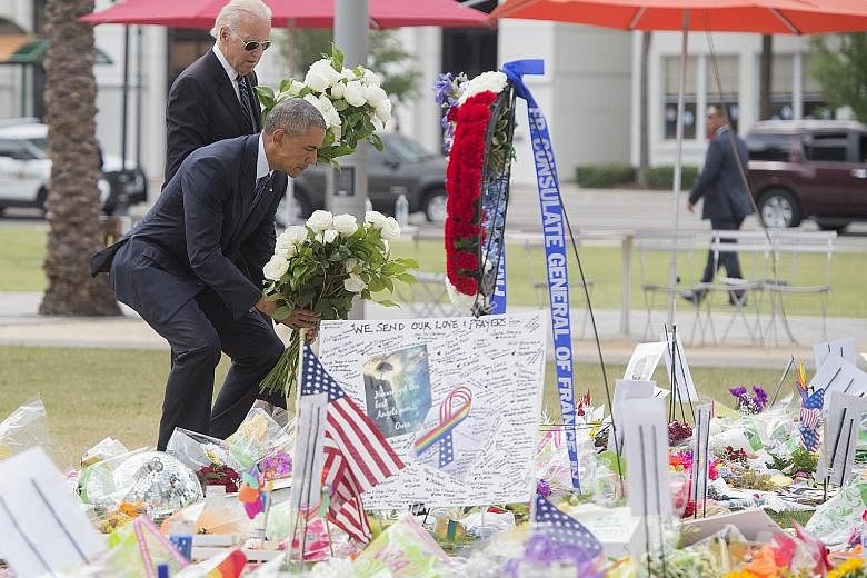 Mr Obama and Mr Biden laying flowers at a memorial at the Dr Phillips Centre for the Performing Arts in Orlando on Thursday for the victims of Sunday's mass shooting at the Pulse nightclub.
