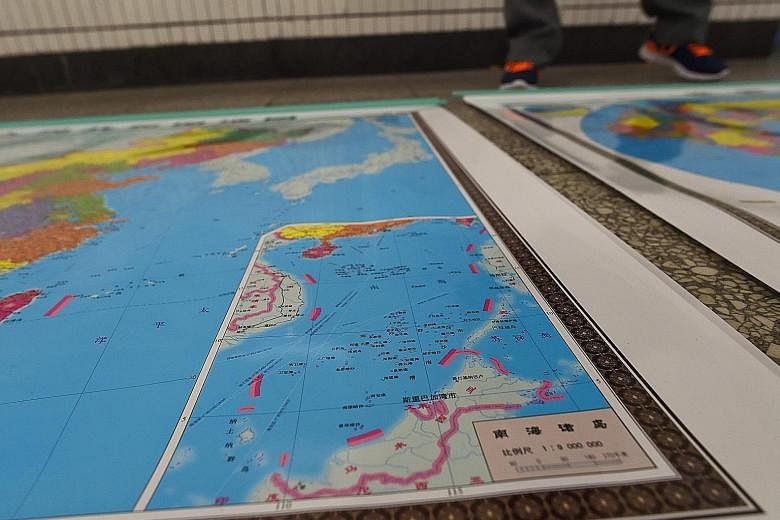 A vendor in Beijing displays a map of China with an inset showing China's claims over territory in the South China Sea denoted by red dotted lines.
