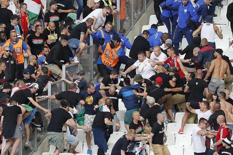 Hungarian fans clashing with stewards ahead of their country's match against Iceland yesterday in Marseille. Witnesses said the stewards had refused to let two fan groups separated by a security barrier into the same section.
