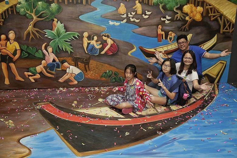 The Chia family, comprising (from right) Mr Chia, his wife Madam Non, and daughters Yuan Ting, 13, and Kar Kar, 10, took "a ride" at the 3D installation depicting the artwork, "Life by the River" by local artist Liu Kang.
