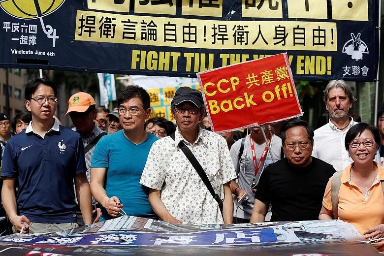 Mr Lam (centre) participating in a protest march in Hong Kong yesterday against the Chinese authorities' "white terror" actions. Thousands of supporters joined in the protest, hailing his courage in going public with the account of his arrest and det