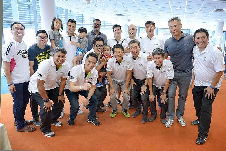 Social and Family Development Minister Mr Tan (wearing yellow sneakers) at the launch of the Dad's for Life football team at yesterday's Dad's Day Out carnival.