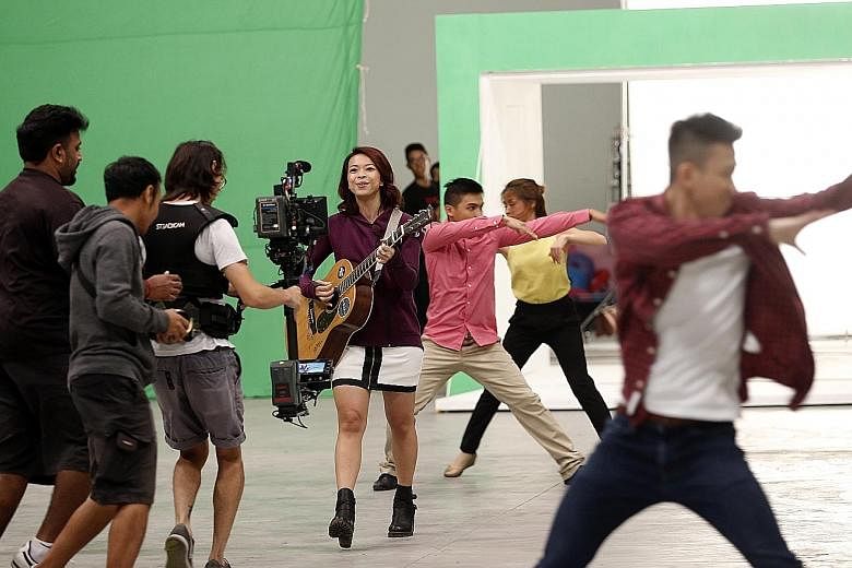 Vocalist Sara Wee from local band 53A, which performs this year's NDP theme song. Shooting the music video for the song involved using "green screen" backdrops, which can be digitally replaced with other images.
