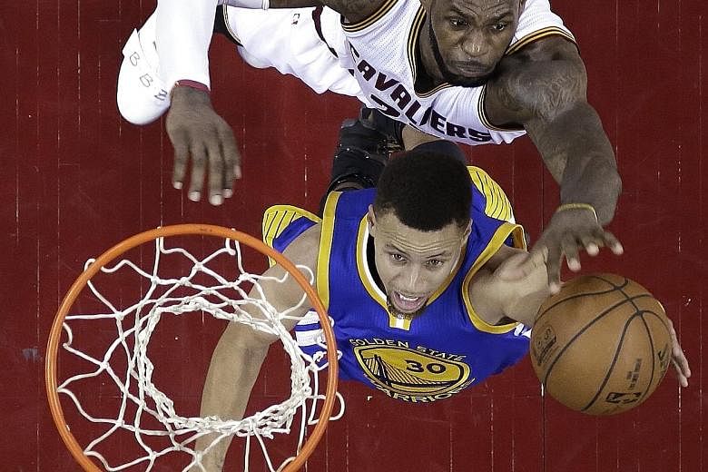 LeBron James (top) of the Cleveland Cavaliers blocks a shot by Stephen Curry of the Golden State Warriors in Game 6 in Cleveland on Thursday. James had back-to-back 41-point performances in Games 5 and 6 as the Cavaliers came back to level the series