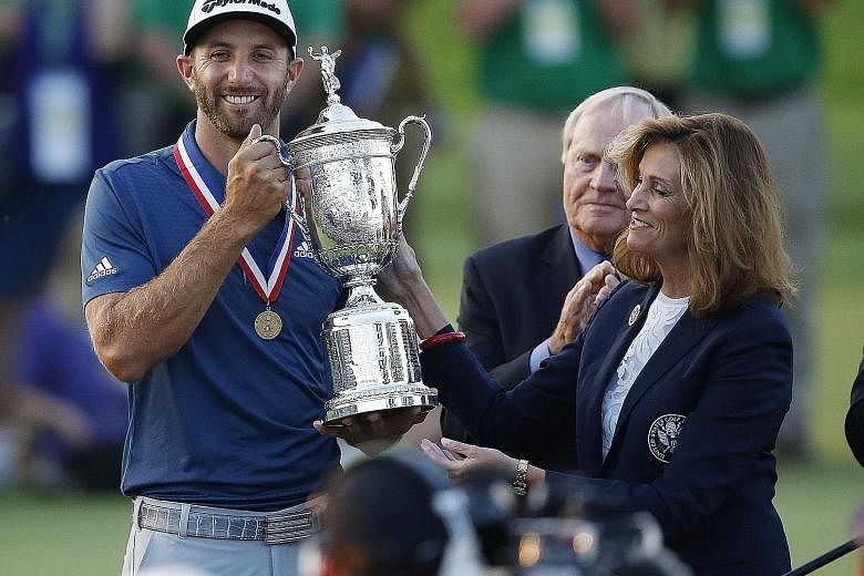 Johnson being presented the trophy after winning the US Open, his first Major, on Sunday.