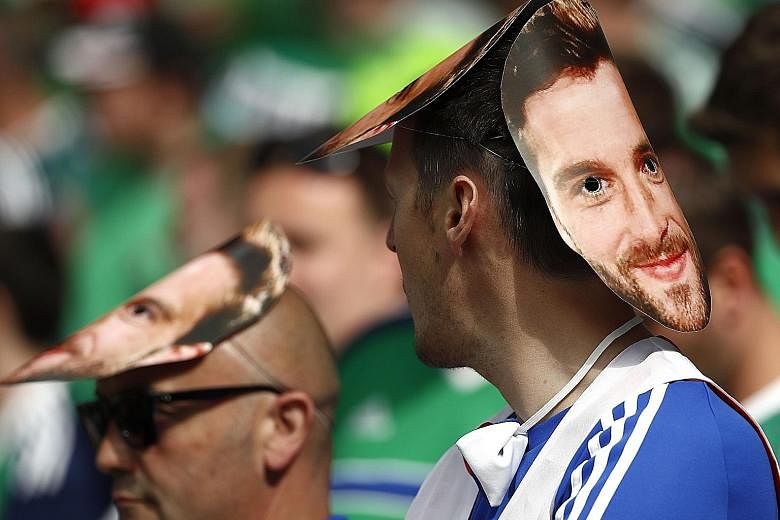 A fan with a mask of Northern Ireland forward Will Grigg waits patiently for the start of the Euro 2016 Group C encounter between Ukraine and Northern Ireland on June 16. Grigg, who has not played so far in the tournament, is the subject of a popular