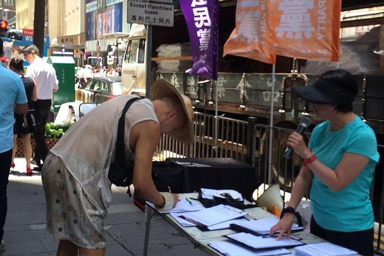 Passers-by in Hong Kong's central district yesterday being invited to sign a street petition calling for the release of the owners of Causeway Bay Books.