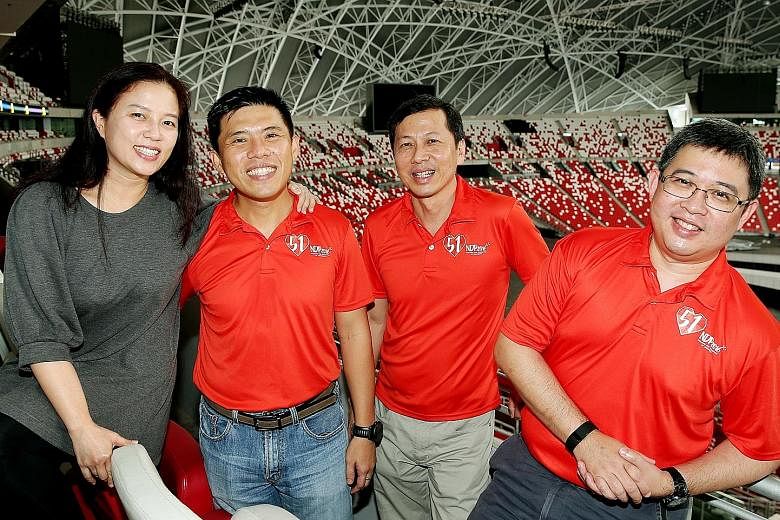 Thirty operationally ready national servicemen have volunteered to help out for this year's National Day Parade - a record number. Among them are LTC (NS) Hoe (second from left) who also roped in his wife Priscilla (extreme left); Col (NS) Lam (third