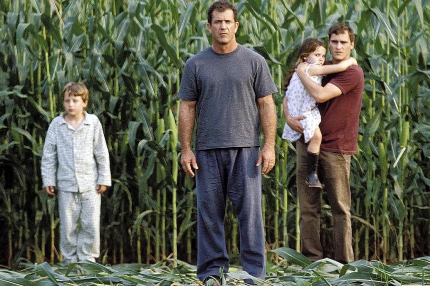 Mel Gibson (centre) as a farmer who finds crop circles in Signs.