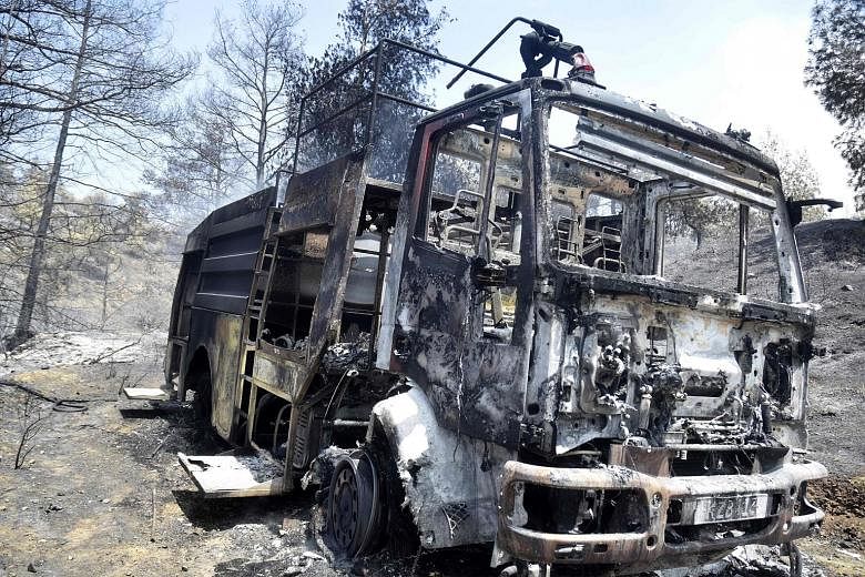 Left: A burnt fire engine from the Cypriot Department of Forest in the village of Evrychou in the Troodos mountain area on Monday.