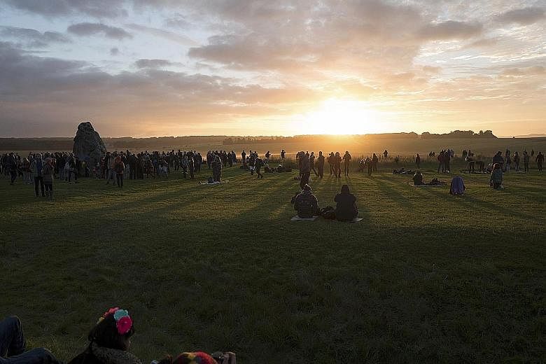 Thousands of people watching the sunrise at Stonehenge in Britain yesterday. They were at the ancient monument site to mark the summer solstice. English Heritage, which seeks to protect historical sites, said about 12,000 watched the sunrise.