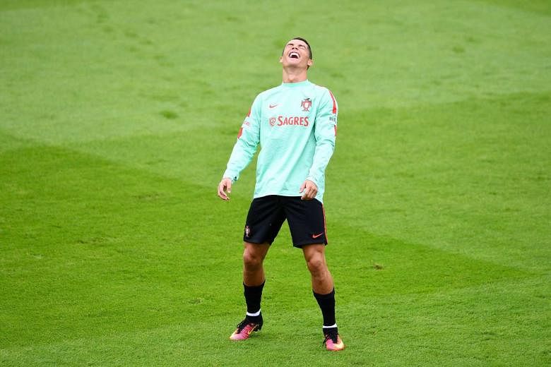Portugal forward Cristiano Ronaldo enjoying a light moment during training at the team's base camp in Marcoussis, south of Paris. It has been a frustrating tournament for him so far, with none of his 20 goal attempts finding the net. 