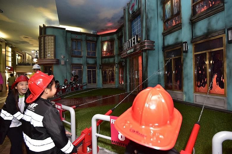 Children under Central Singapore District's Nurture 2.0 programme play-acting as firemen at KidZania yesterday. The volunteer scheme that helps kids with maths and English now includes non-academic activities with StarHub's support in the past six ye