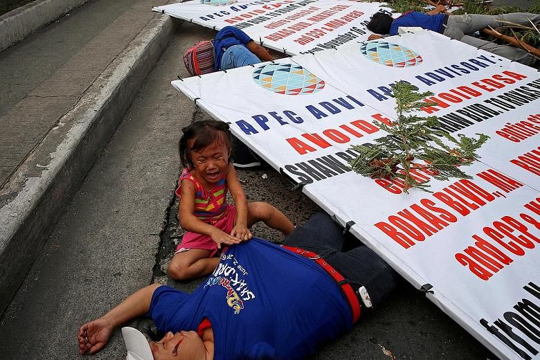 A metrowide earthquake drill held yesterday along the main EDSA highway in Makati, Metro Manila, in the Philippines is a serious exercise for this little girl who cries next to her mother who was recruited to play the role of an earthquake casualty.