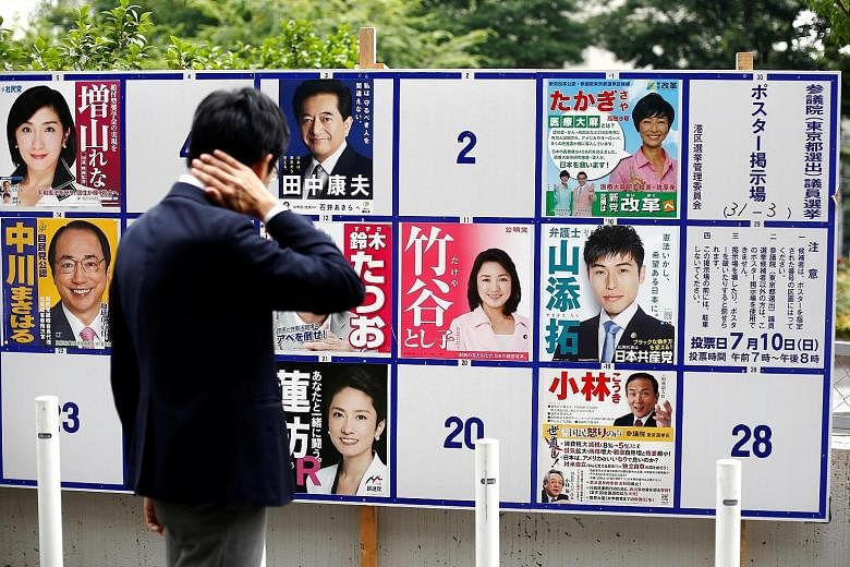 Campaign posters of candidates of the July 10 Upper House elections in Tokyo yesterday. Media surveys this week show that Mr Abe's ruling bloc will likely win the polls. Mr Abe speaking with the quake-damaged Kumamoto Castle in the background as camp