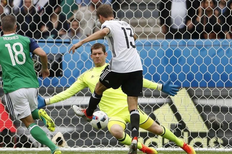Germany's Thomas Muller failing to score past Northern Ireland goalkeeper Michael McGovern. Both sides reach the last 16 after the Germans' 1-0 win.  