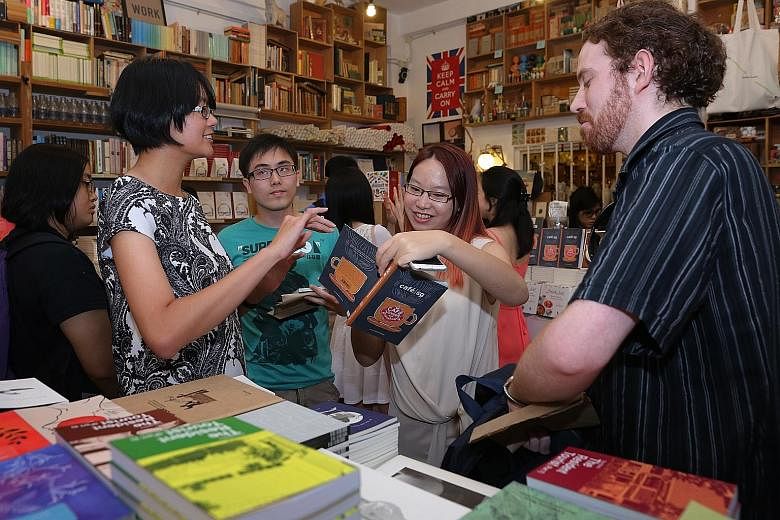 Mr Jerome Lim and Mr James Miller chatting with Straits Times journalists Janice Heng (far left) and Charissa Yong at the book launch at Books Actually in Tiong Bahru.