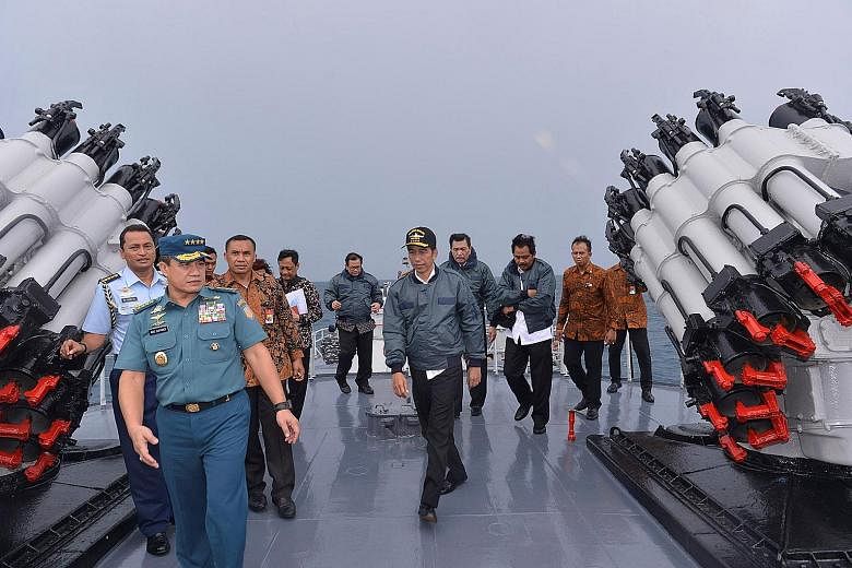Indonesian President Joko Widodo (centre) on board the navy warship KRI Imam Bonjol yesterday, accompanied by several Cabinet ministers and other top officials. SEE TOP OF THE NEWS A4