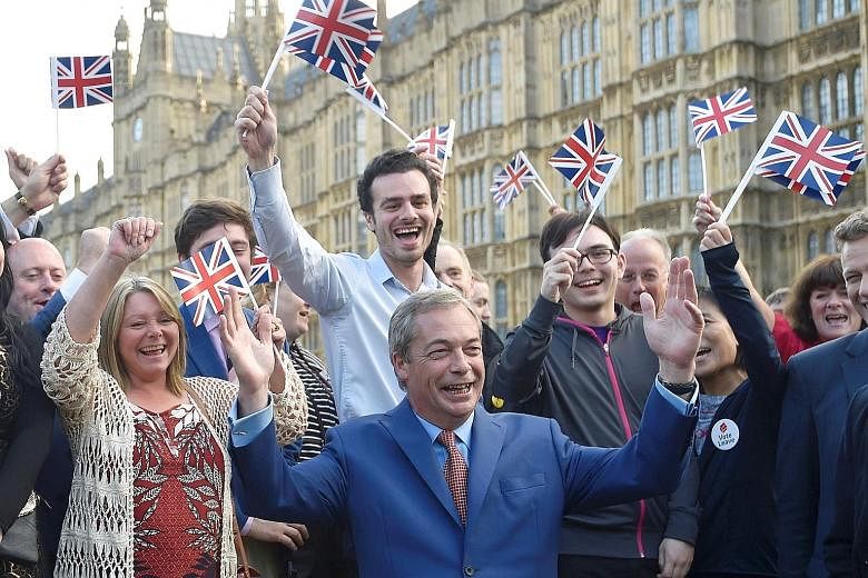 UK Independence Party leader Nigel Farage and "Leave" supporters cheering the referendum outcome yesterday. He had said Prime Minister David Cameron should immediately resign if Brexit became a reality. A taxi driver in central London displaying a Un