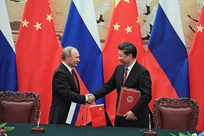 Russian President Vladimir Putin and Chinese President Xi Jinping at a signing ceremony after their meeting in Beijing yesterday. Mr Putin is forging closer ties with China at a time when Russia is in need of trade because of Western sanctions impose