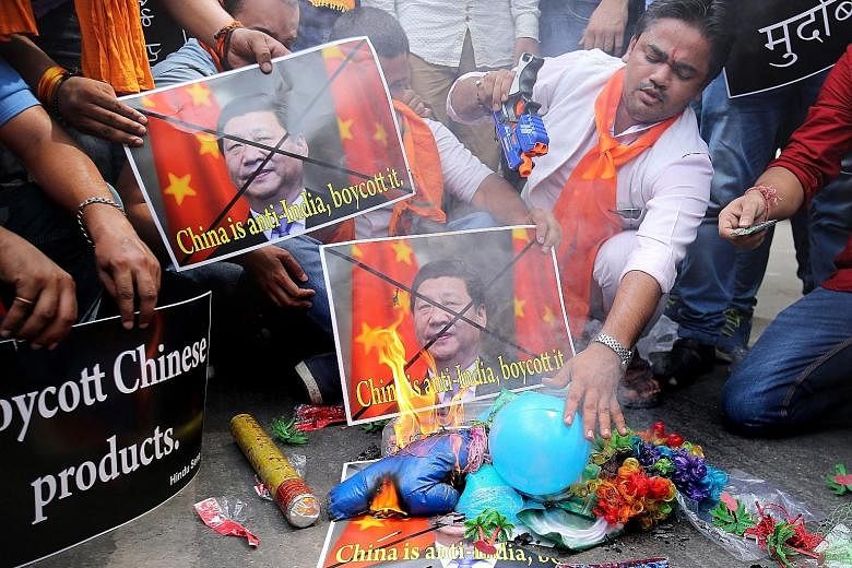 Indian activists from the right-wing Hindu Sena group burning posters of Chinese President Xi Jinping during a protest yesterday over China's perceived anti-India bias in the Nuclear Suppliers Group.