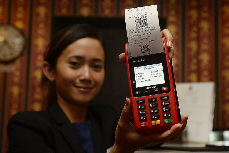 Jinshan Hotel manager Amelia Wahjoto with SwiftPay's terminal that accepts four types of platforms - WeChat Pay, Alipay and Baidu, and UnionPay cards.