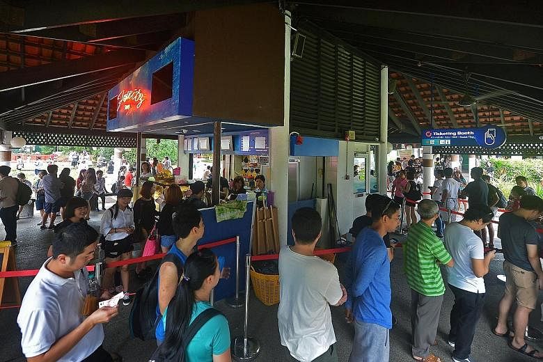 Left: Visitors taking snaps and selfies in the attraction's underwater tunnel. Below: All in, about 8,500 residents and tourists thronged the 25-year-old attraction in Sentosa yesterday - more than five times the average daily visitorship.