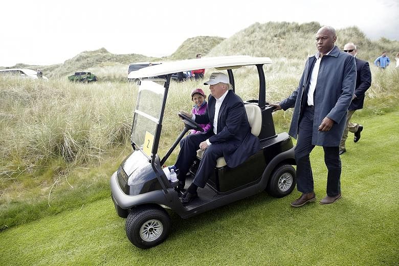 Mr Donald Trump driving a golf cart at his Trump International Golf Links in Aberdeen at the weekend.