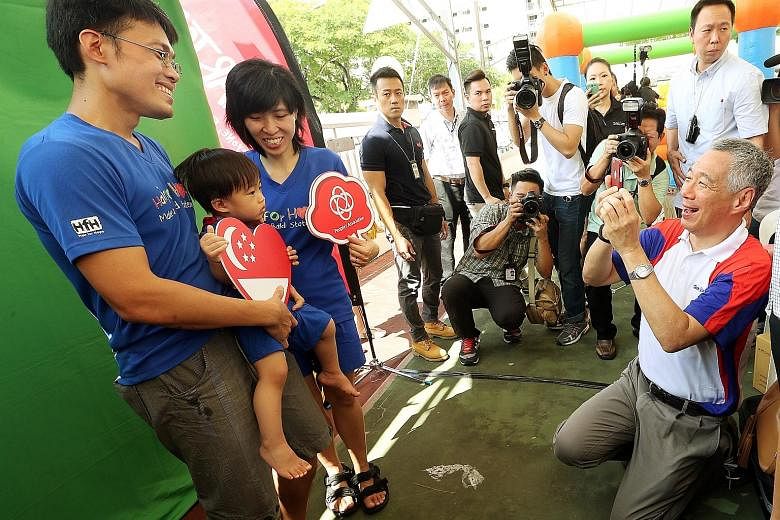 Prime Minister Lee Hsien Loong played photographer yesterday at the Teck Ghee Family Day, as he shot a family portrait for Mr Low Kang Yin, 37, his wife Ong Lizhen, 34, and their 19-month- old son Valen. Known for being a photo buff, Mr Lee took phot