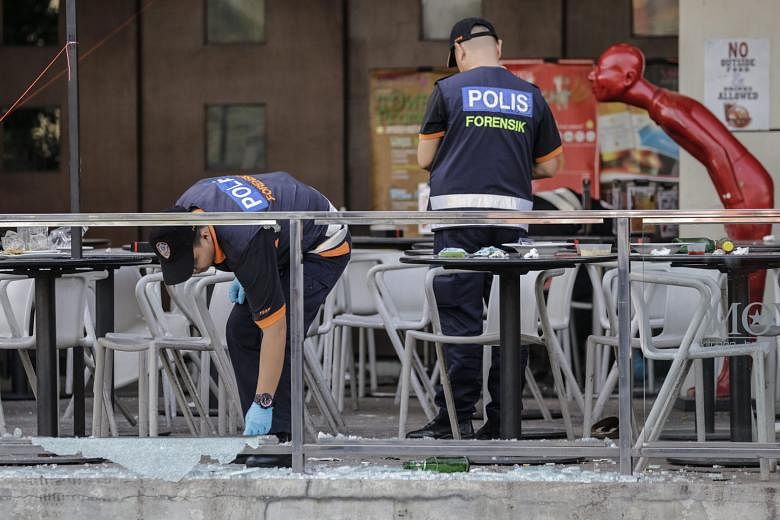 Forensic officers gathering evidence at the pub in the IOI Boulevard mall in Puchong, near Kuala Lumpur, yesterday. Patrons were watching a Euro 2016 football match when a hand grenade exploded at about 2.15am. The police said the incident was not an act 