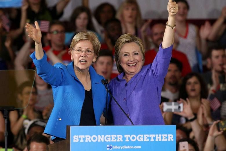 Mrs Clinton (right) with Mrs Warren at Monday's rally in Cincinnati. Wearing similarly coloured clothes, they cheered each other on like old pals, cracking jokes about Mr Donald Trump. 