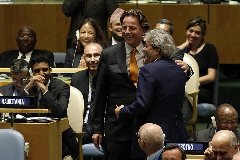Dutch Foreign Minister Bert Koenders (wearing yellow tie) greeting his Italian counterpart Paolo Gentiloni at the UN headquarters in New York on Tuesday. Under an agreement which will be put to a vote, Italy will serve on the council next year, follo
