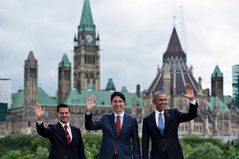 (From left) Mexican President Enrique Pena Nieto, Canadian Prime Minister Justin Trudeau and US President Barack Obama posing for a group photo with Canada's Parliament Hill in the background during the North American Leaders' Summit on Wednesday in 