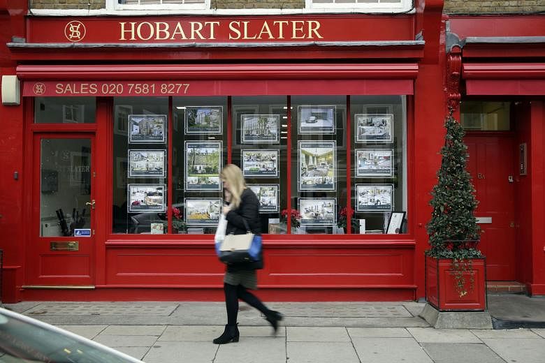 Residential property information leaflets displayed in the window of an estate agent in the Knightsbridge district of London in 2014. Unlike the escalating value of homes in the city then, analysts predict that the pendulum will swing the other way now, w