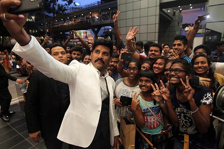Stars from the Tamil and Malayalam film industries such as singer Vijay Yesudas (left) and Vedhika (above) took wefies with fans as they walked the red carpet last night at the South Indian International Movie Awards. Hundreds of fans clamoured for t