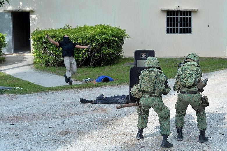 Troops from the Army Deployment Force, the SAF's new anti-terrorist unit, responding to a mock attack during a demonstration on Wednesday.
