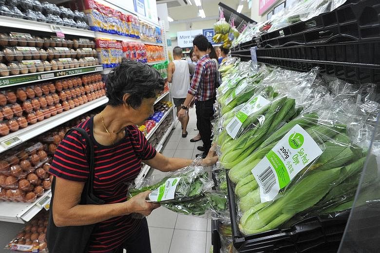 Housewife Yap Lai Choo, 75, browsing Value Fresh brand vegetables at a FairPrice Shop that opened yesterday in Eunos Crescent. The vegetables under this new FairPrice brand are 5 per cent to 10 per cent cheaper than the items from the supermarket cha