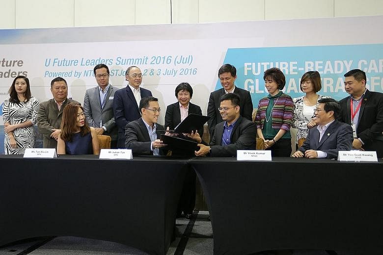 The MOU was signed by Mr Julian Tan, executive vice-president of SPH Digital, and Mr Vivek Kumar, director of U Associate and U Future Leaders, NTUC (seated, centre). It was observed by SPH CEO Alan Chan (standing, fourth from left) and NTUC secretar