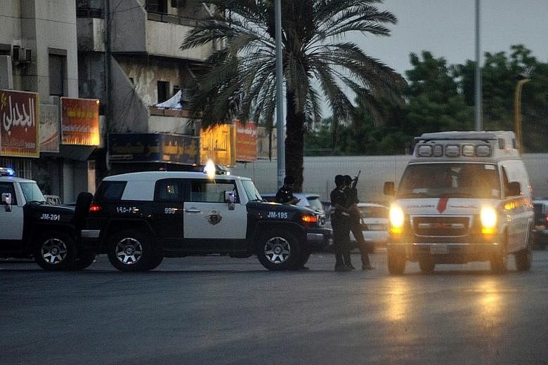 Police officers at the site of the suicide bombing in Jeddah yesterday. The attacker parked his car near the US consulate and detonated his device after two guards approached him, killing him and injuring them.