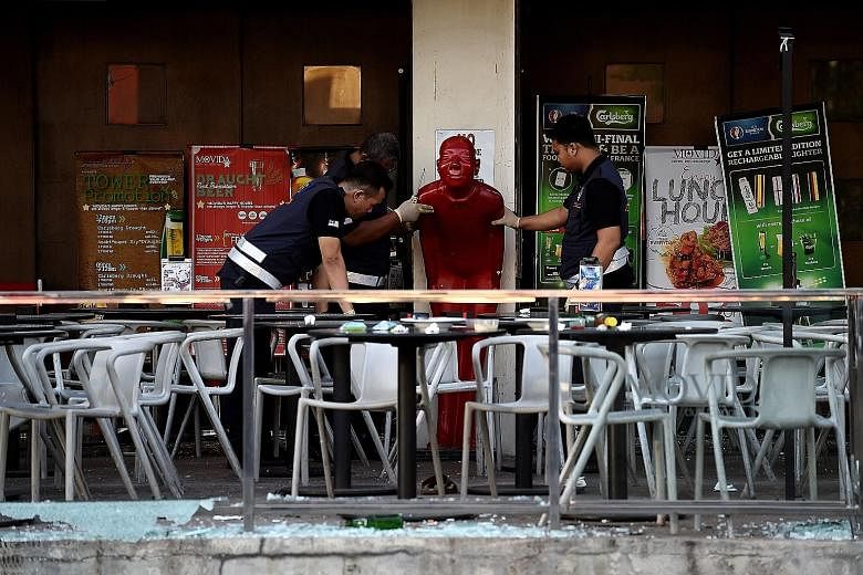 Malaysian forensic officers inspecting the bar in Puchong, the site of the grenade attack last Tuesday in which eight people were injured. Police initially said that a business rivalry or a targeted attack on someone in the pub were the likely motive