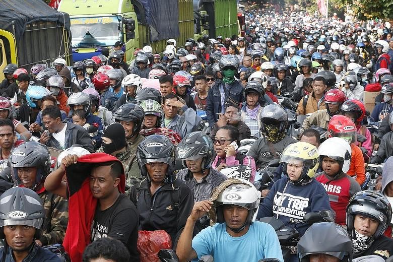 Indonesian motorcyclists prepare to board a ferry in Bali on Sunday ahead of the Eid al-Fitr festival tomorrow, also called Lebaran in Indonesia and Hari Raya Puasa in Malaysia. Millions of Muslims head to their home towns in the annual migration, pa