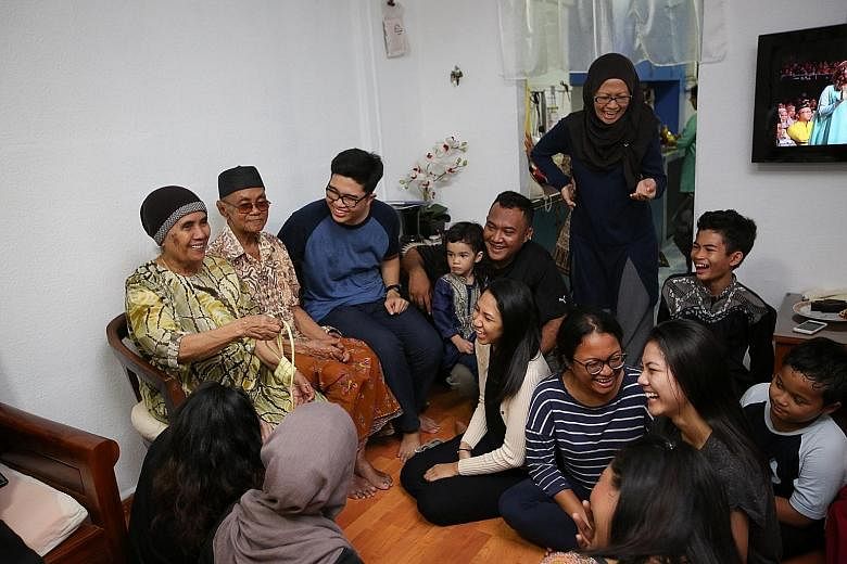 Madam Suryani (standing) and her family spanning four generations having a merry time at the flat of her grandparents - Mr Yasin Karim, 90, and Madam Siti Jibah, 84 (both seated) - yesterday.