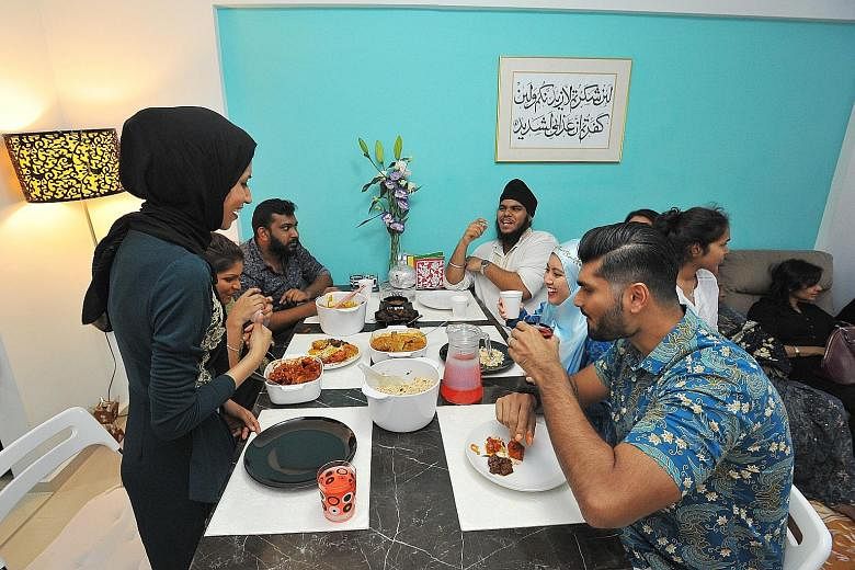 Flight attendant Noor Mastura (far left), 26, invited guests of other faiths into her home yesterday to experience Hari Raya Aidilfitri festivities and share a meal with her family members. She hosted copywriter Sumalatha Navanesan, 26, a Hindu; adve
